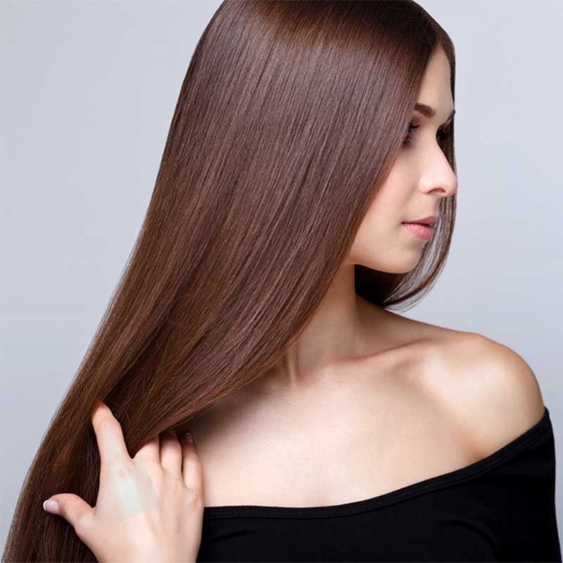 Mujer con cabello chocolate y liso perfecto hecho con Three Therapy - Nanoplastia - Alisado Orgánico y Vegano con Tecnología Anti-adelgazamiento